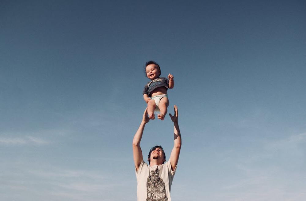 Father tossing his son into the air