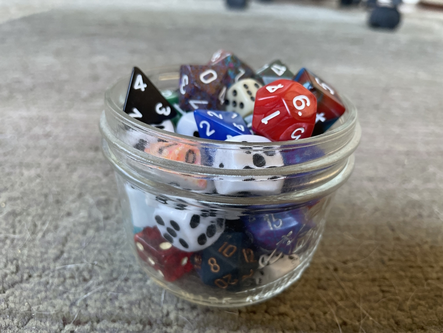 "Small glass cup filled with dice"