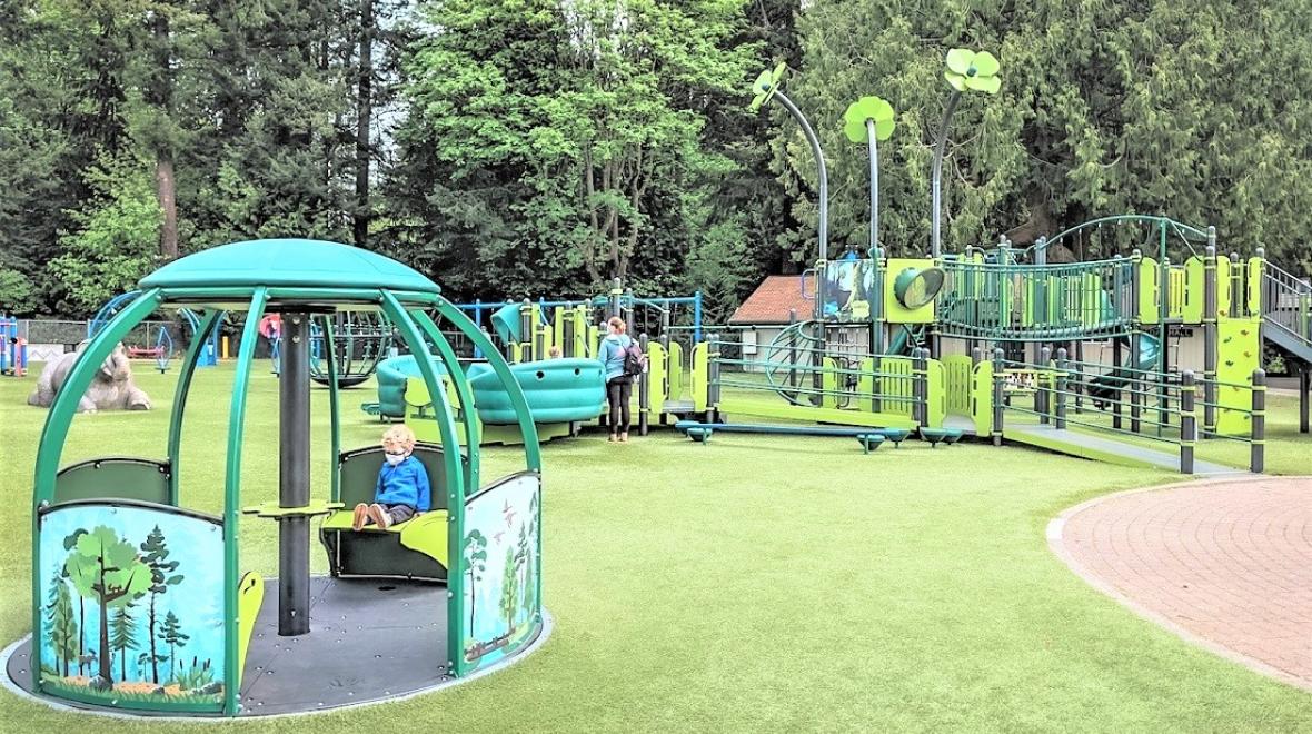 Kids play on the inclusive accessible play equipment at Everett, Washington's Forest Park updated playground and ParentMap's playground of the week