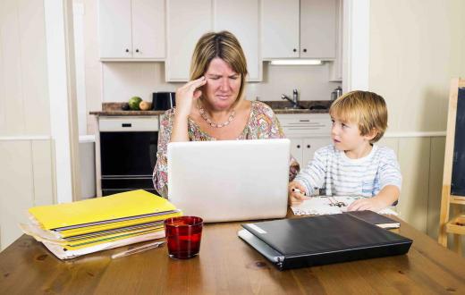 Frustrated mom sitting at table with young son