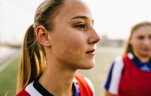 closeup of a serious sporty teen girl wearing a jersey outdoors