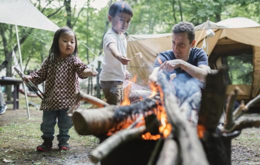 Dad-and-kids-setting-up-camp-fire