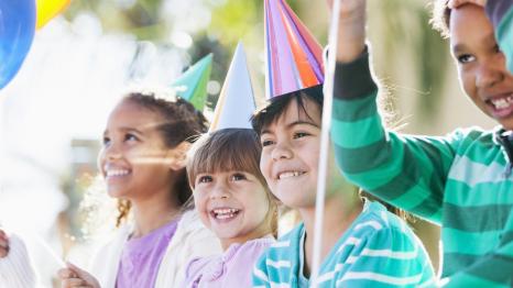 Happy kids wearing party hats at a birthday party