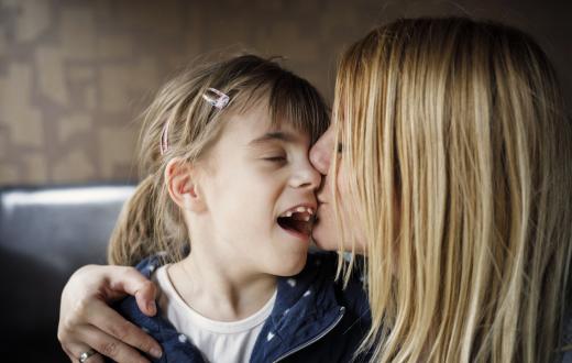 Mom kissing her child with special needs