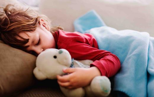 Sleeping child holding teddy bear